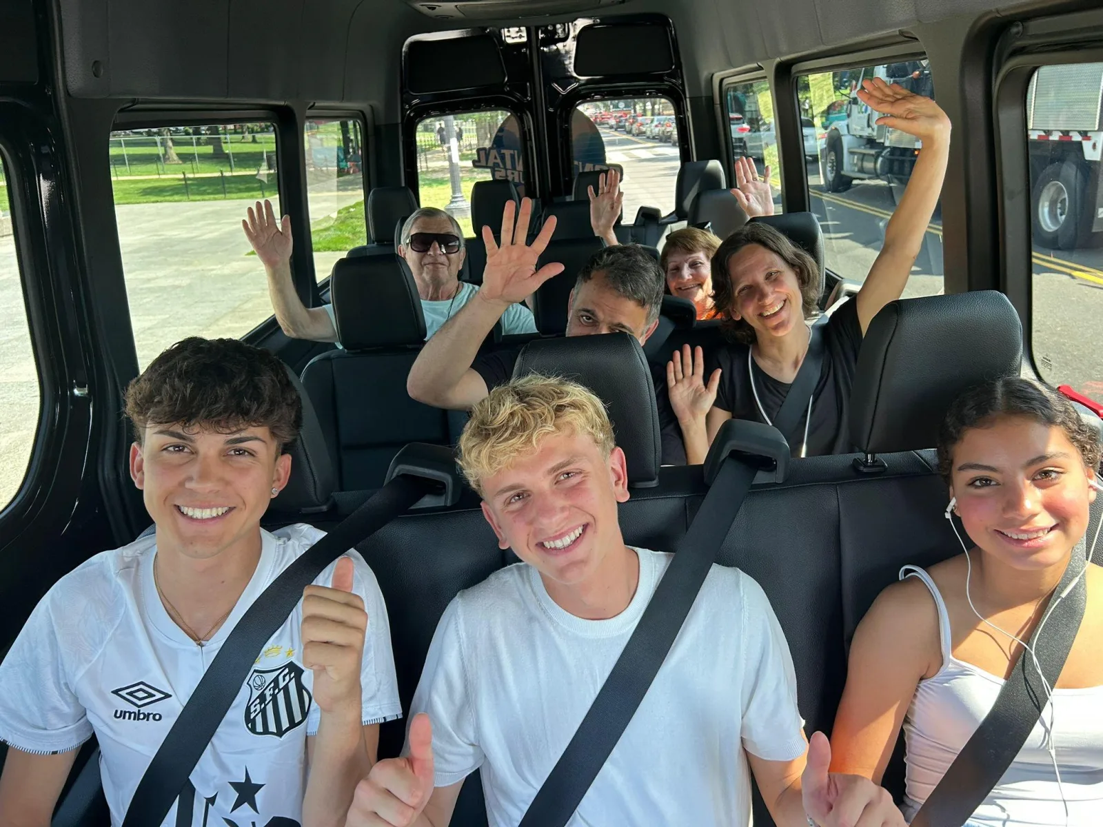 A group of teenagers smiling inside the tour van